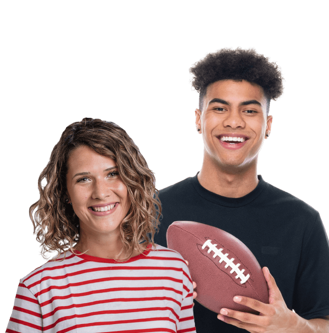 Highschool-age kids, girl in foreground and boy in background holding football